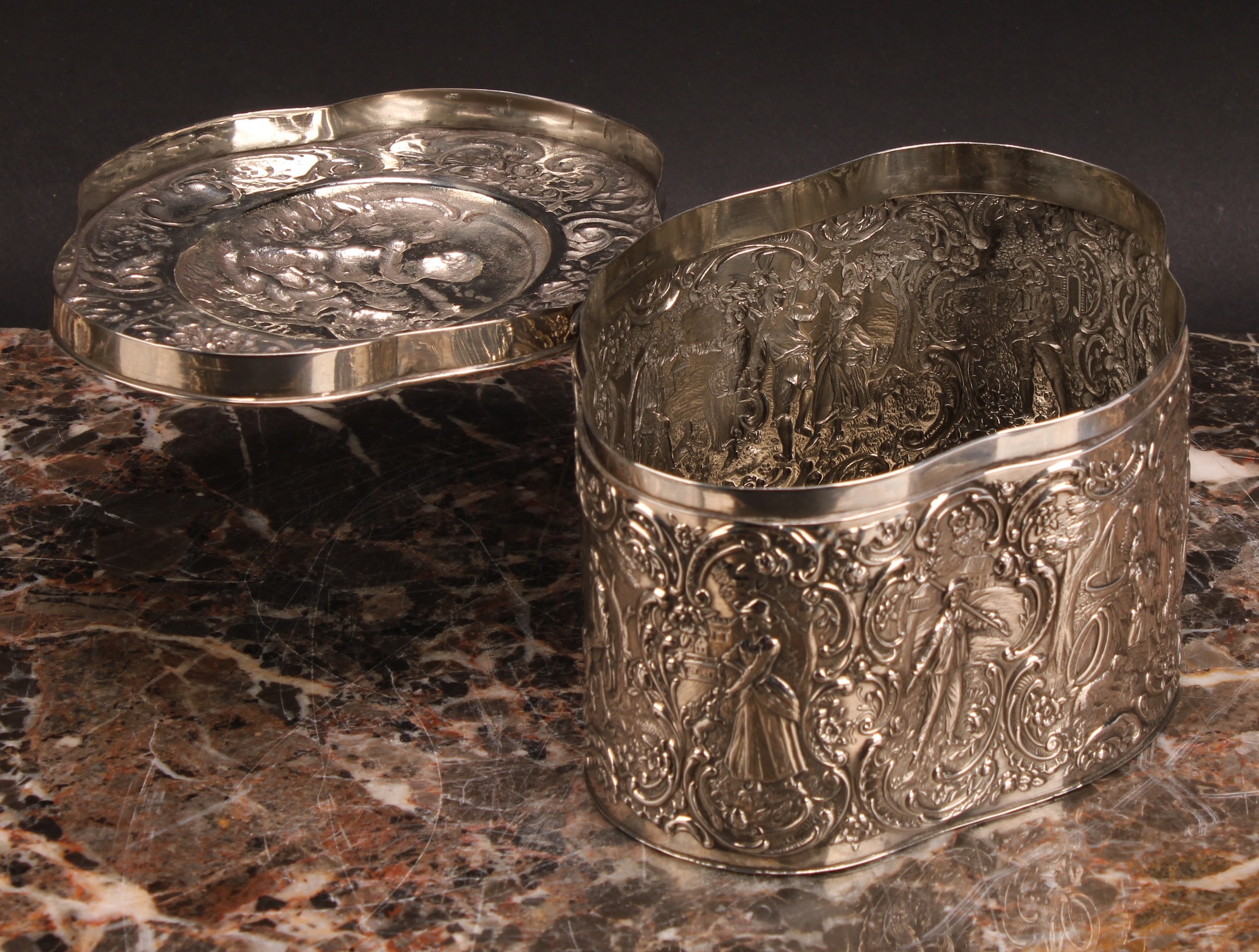 A Continental silver coloured metal oval quatrefoil biscuit box or tea caddy, repousse chased with - Image 4 of 4