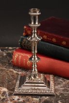 An early George III cast silver taperstick, knopped pillar, stepped square base with gadrooned