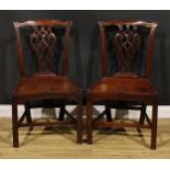 A pair of George III red walnut/mahogany hall chairs, each with Cupid’s bow cresting rail above a