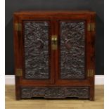 A Chinese hardwood side cabinet, flush rectangular top above a pair of panel doors, each carved with