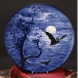 A Royal Worcester Aesthetic Movement circular charger, painted with bats against a moonlit sky, in