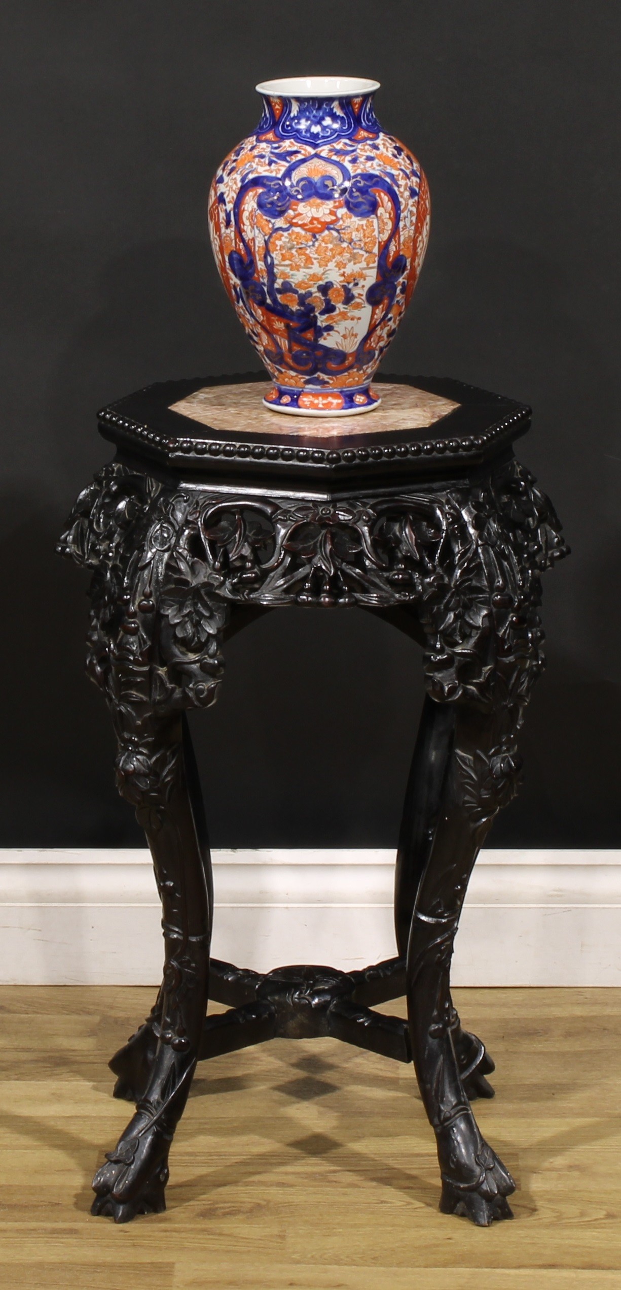 A Chinese hardwood jardiniere stand, octagonal top with beaded border and inset marble panel, shaped