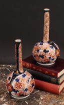 A pair of Japanese porcelain bottle vases, decorated in the Imari palette with peonies and