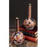 A pair of Japanese porcelain bottle vases, decorated in the Imari palette with peonies and