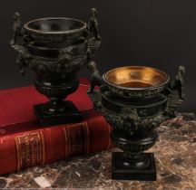 A pair of late 19th century dark patinated bronze urns, cast in the Classical and Egyptian Revival