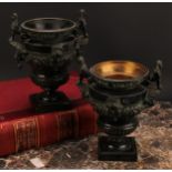 A pair of late 19th century dark patinated bronze urns, cast in the Classical and Egyptian Revival
