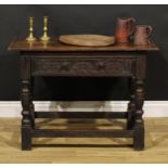 A 17th century oak side table, oversailing top above a long frieze drawer carved with leafy