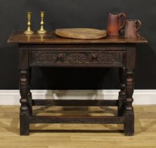 A 17th century oak side table, oversailing top above a long frieze drawer carved with leafy