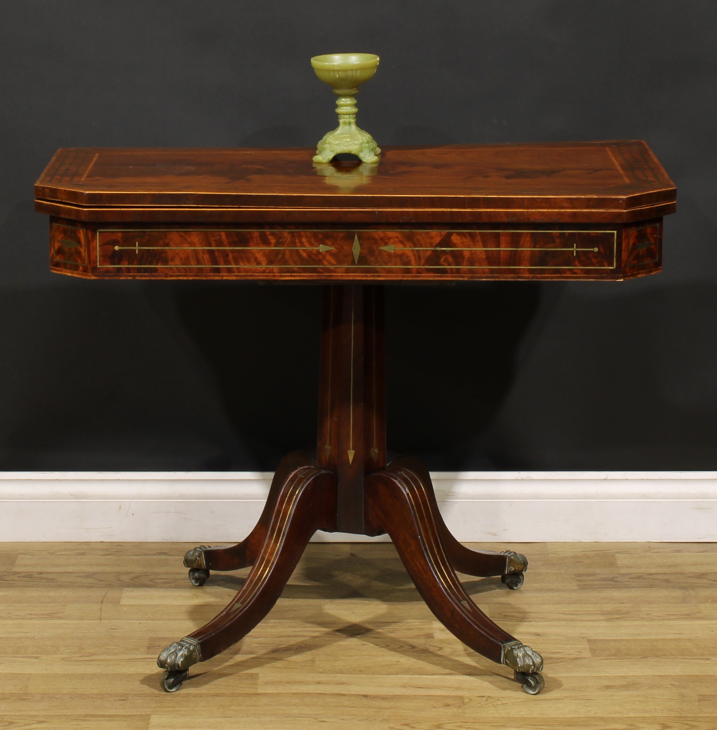 A Regency mahogany and brass marquetry card table, hinged top enclosing a baize lined playing