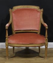 A Louis XVI Revival giltwood elbow chair, of broad proportions, stuffed-over upholstery, fluted