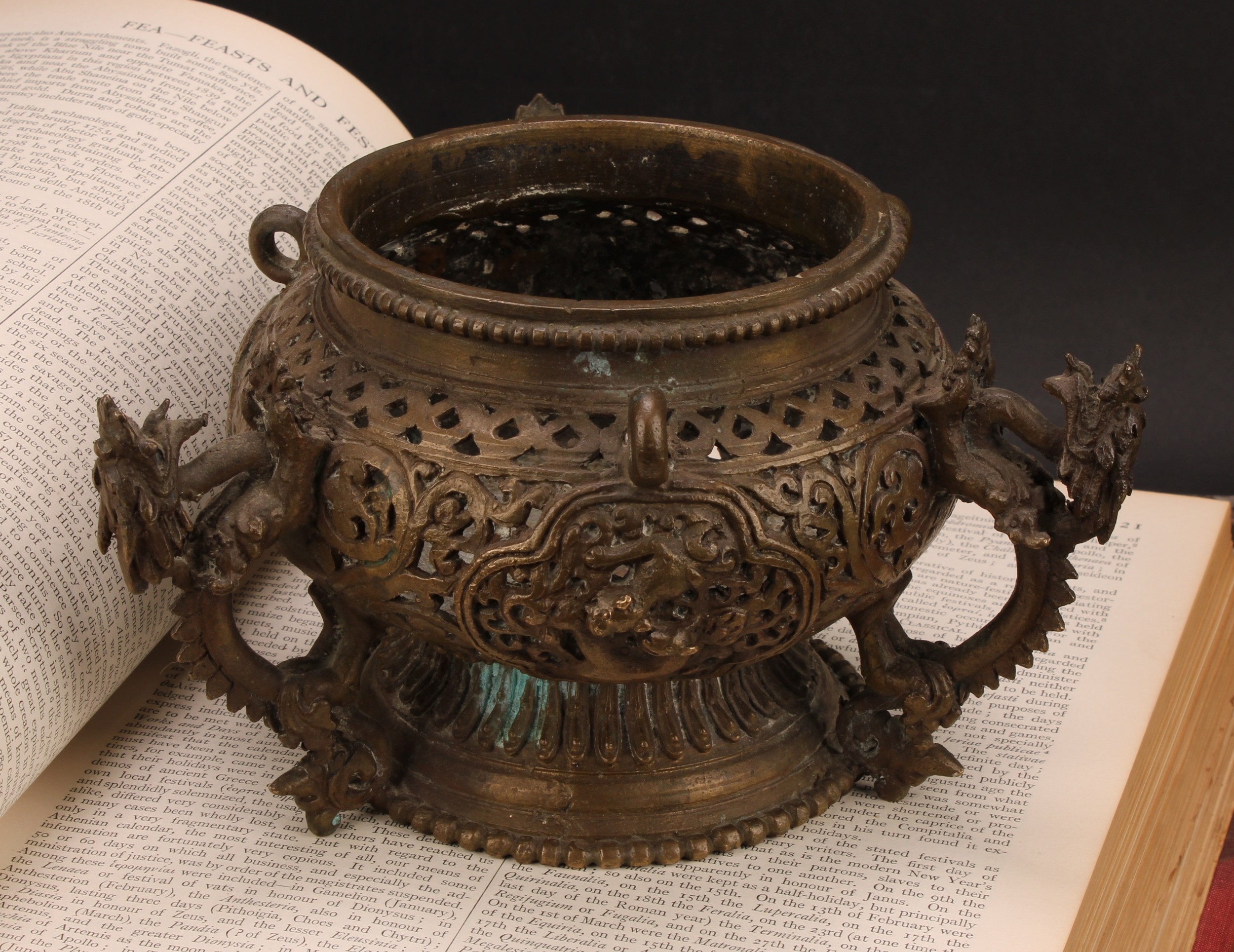 A Chinese bronze hanging censer, pierced and cast with dragons, temple lions and scrolls, 18.5cm