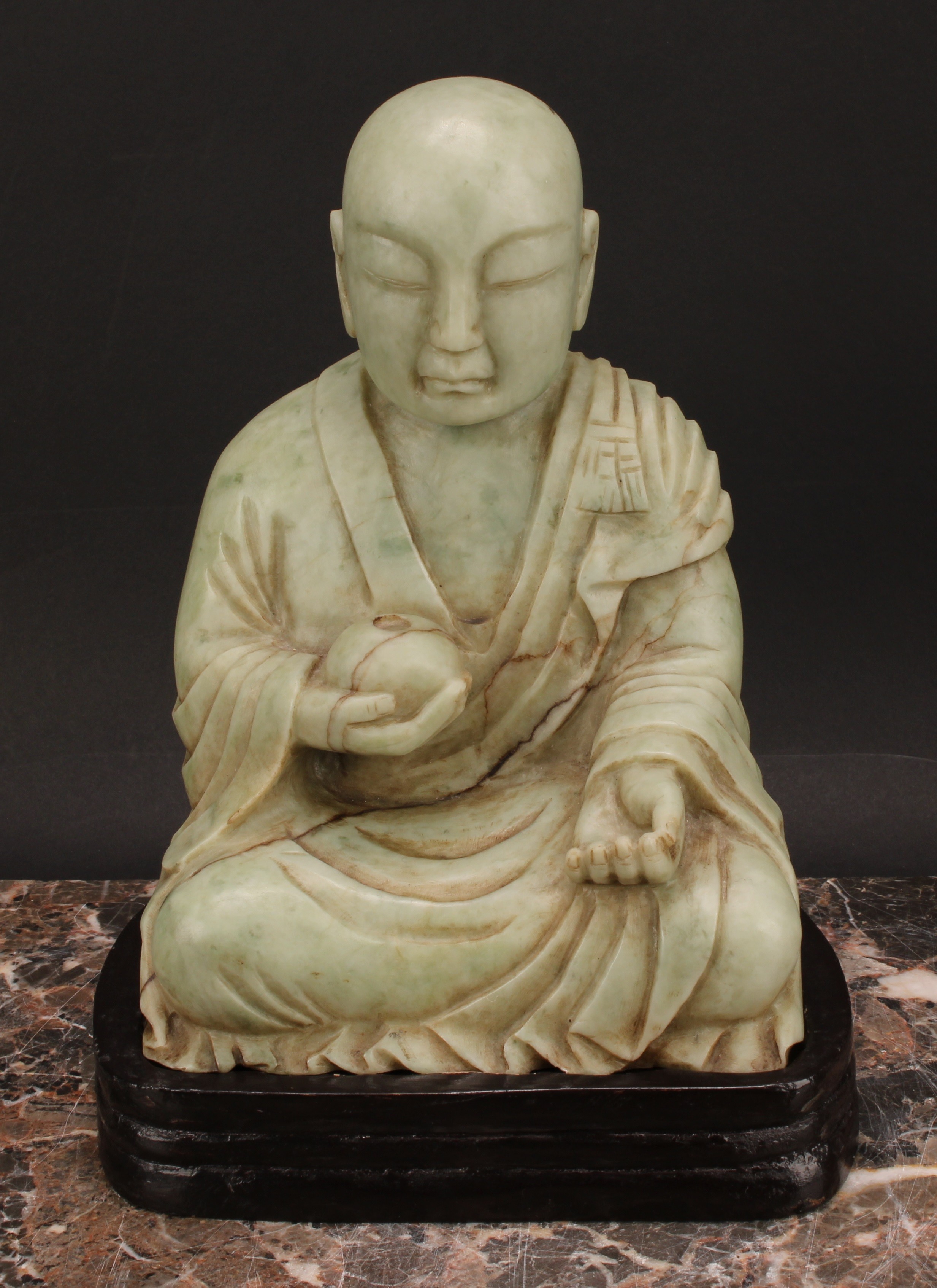 A Chinese soapstone figure, carved as a Buddhist disciple, or Luohan, holding a peach, 21cm high, - Image 2 of 4