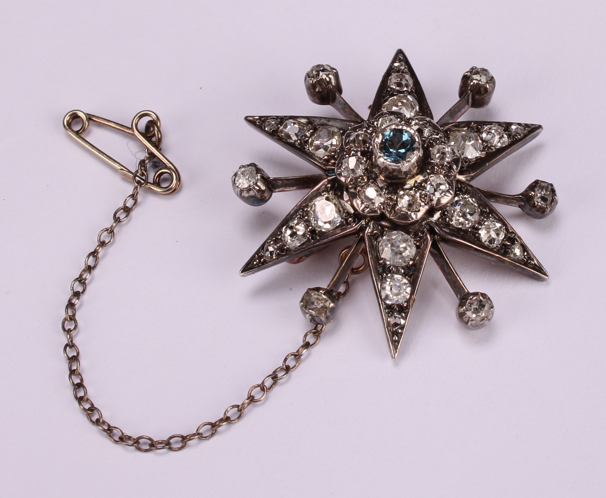 A diamond radiating starburst brooch, set with old cut stones, the central stone a faceted - Image 2 of 3
