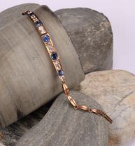 A rose metal mounted bluie and white sapphire articulated bracelet, set with five graduated blue