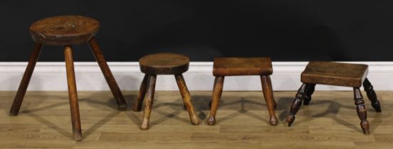 A 19th century elm milking stool, 38cm high, the seat 26cm diameter; similar candle stools (4)
