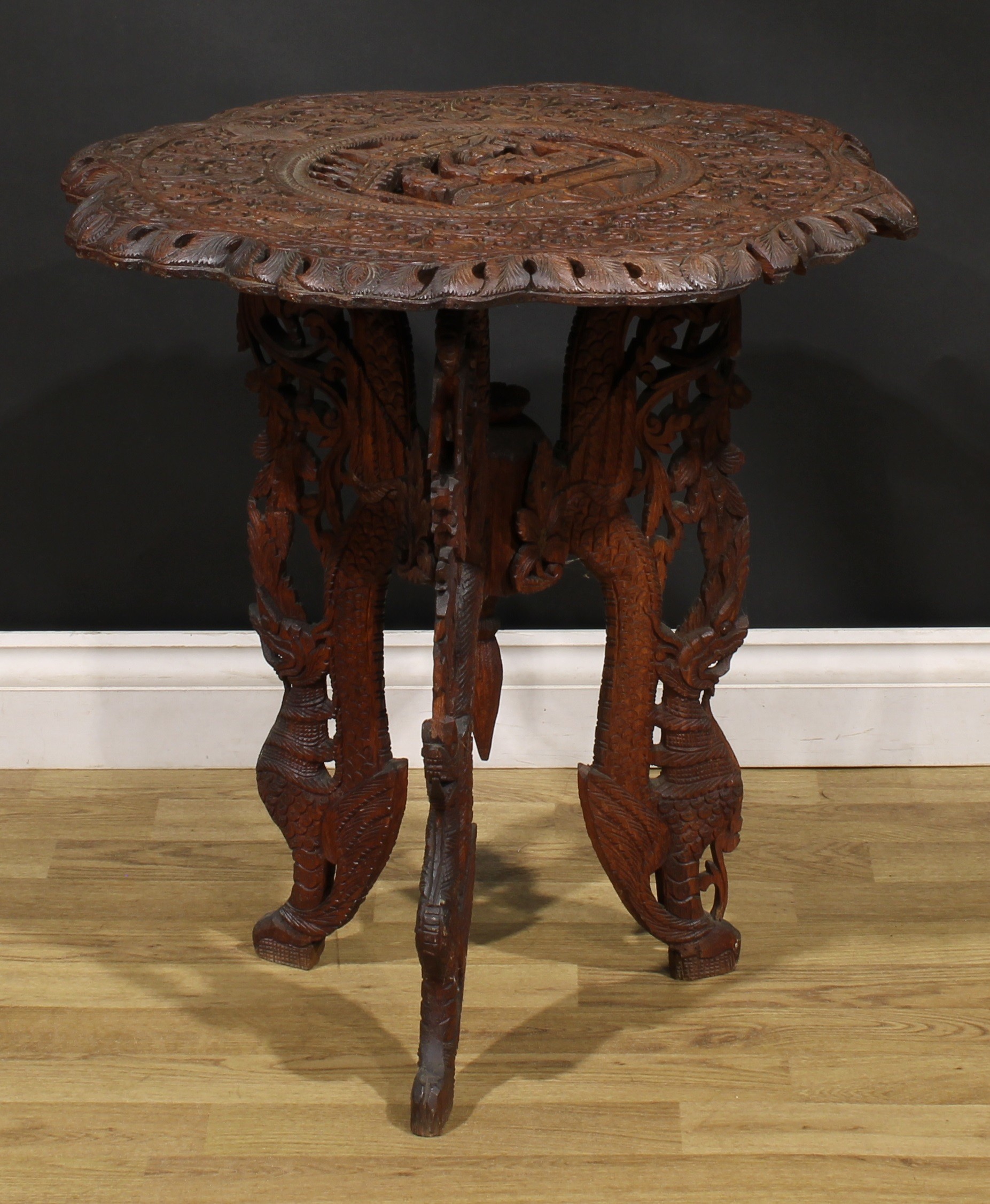 An Anglo-Indian hardwood occasional table, shaped circular top carved with deities within a band - Image 2 of 3