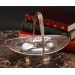 An Edwardian silver navette shaped swing-handled sweetmeat dish, pierced and bright-cut engraved