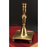A Spanish brass tray base socket candlestick, knopped pillar, domed socle, fluted feet, 23cm high,