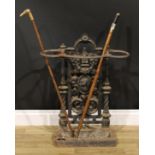 A Victorian cast iron walking stick or umbrella stand, cast with a portrait amongst fruiting
