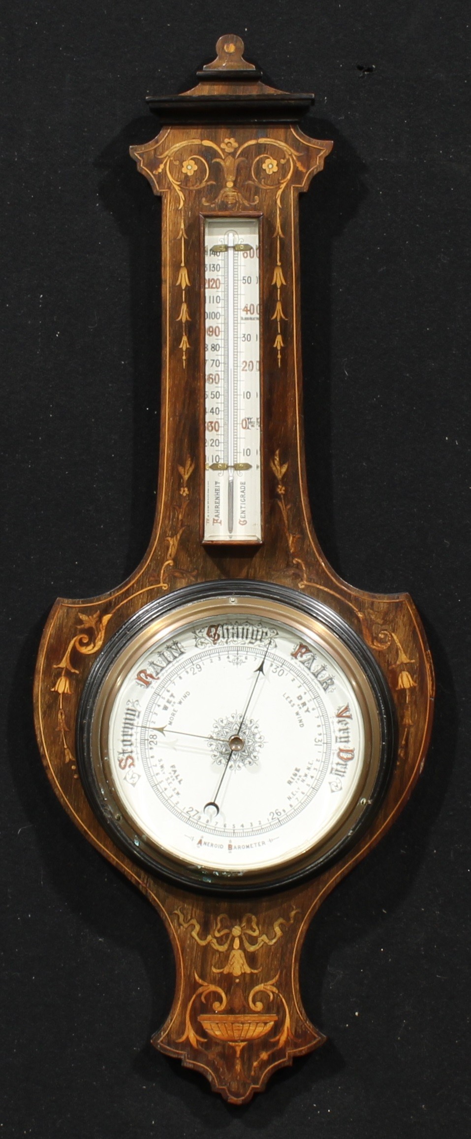 An Edwardian rosewood and marquetry shield-form wheel barometer, 18.5cm circular register, the