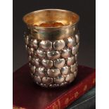A German silver snakeskin type beaker, chased with rows of hearts, gilt interior, 9.5cm high, 13