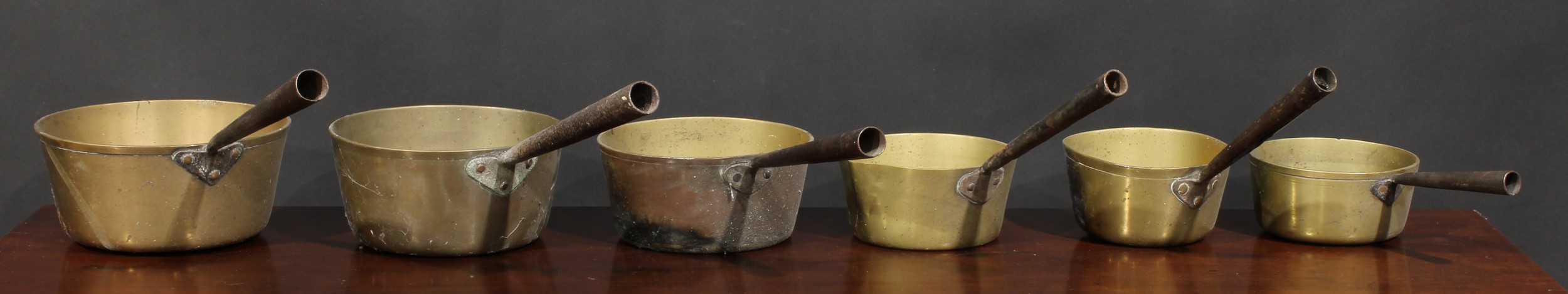 A 19th century harlequin graduated set of six brass and steel saucepans, the largest 21.5cm diameter