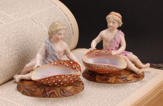 A pair of 19th century Sitzendorf figural table salts, of children holding seashells, decorated in