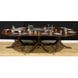 A large Regency Revival mahogany triple-pillar dining table, discorectangular top with reeded edge,