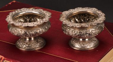 A pair of George IV silver ovoid pedestal salts, chased with floral band with vacant laurel wreath