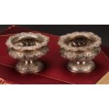 A pair of George IV silver ovoid pedestal salts, chased with floral band with vacant laurel wreath