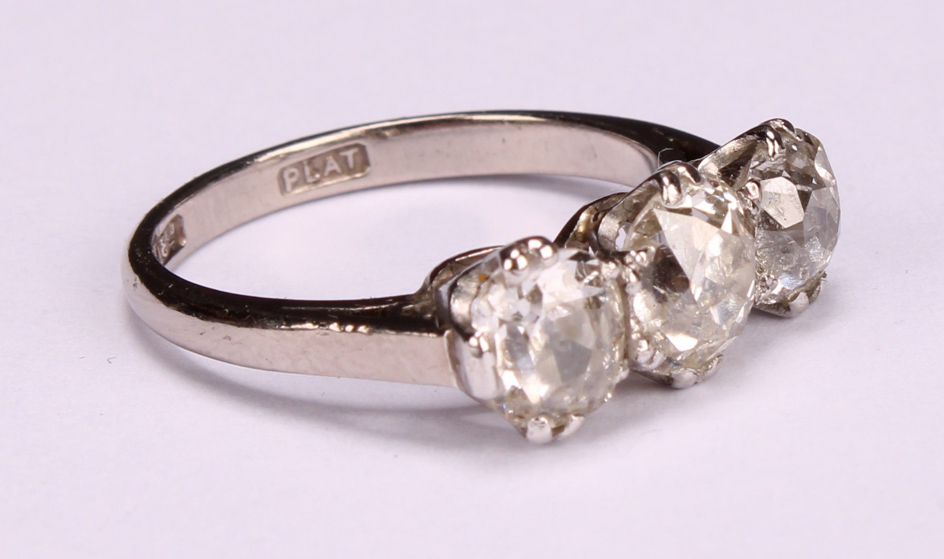 A diamond three stone ring, the central round brilliant cut stone flanked by two smaller stones, - Image 2 of 4