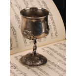 An Arts and Crafts silver coloured metal goblet, cast and chased with stylised fruiting vine, 14.5cm