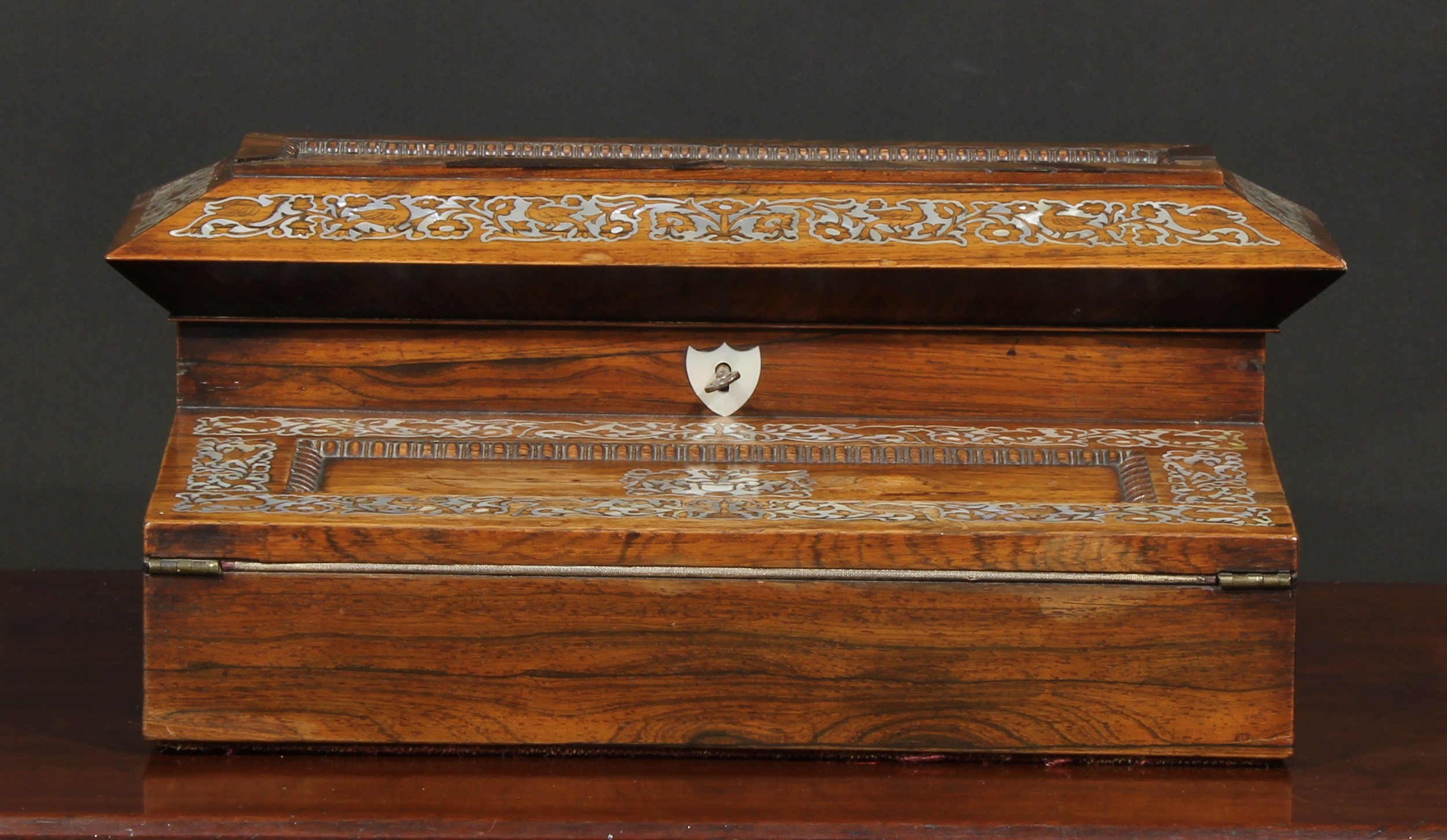 A 19th century rosewood and mother of pearl inlaid writing box, hinged cover enclosing fitted