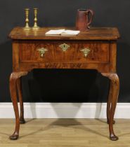 A George I walnut lowboy, quarter-veneered crossbanded top with reentrant angles, above a long