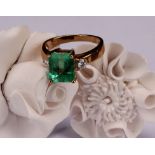 An 18ct gold, emerald and diamond ring, central cushion cut stone