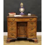 A George III mahogany kneehole desk, rectangular top with moulded foliate carved edge centred by a