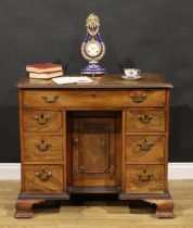 A George III mahogany kneehole desk, rectangular top with moulded foliate carved edge centred by a