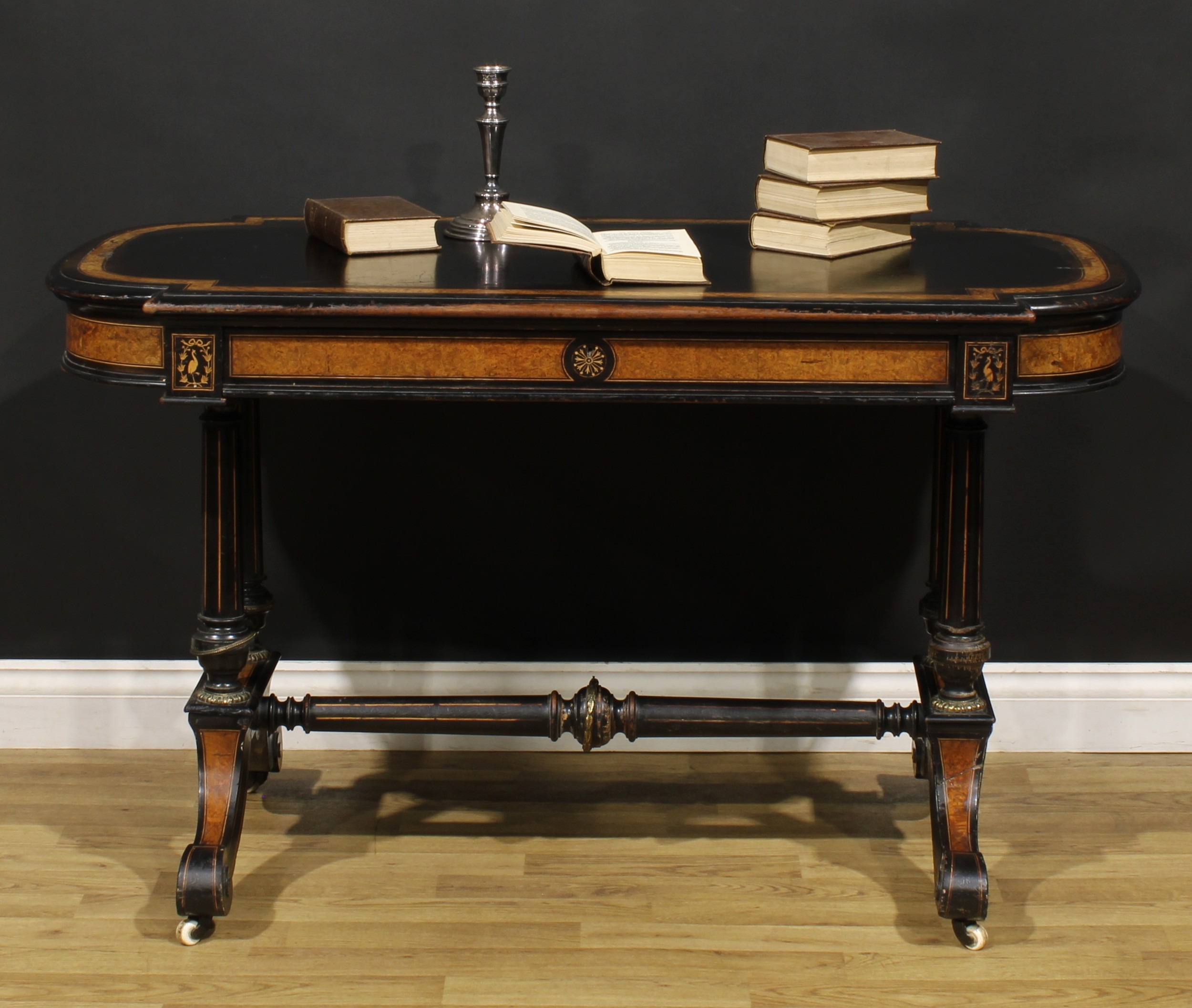 A Victorian amboyna banded ebonised library table, slightly oversailing top with moulded edge