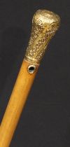An 18th century gold mounted walking stick, spirally fluted pommel crested and chased with ribbon-