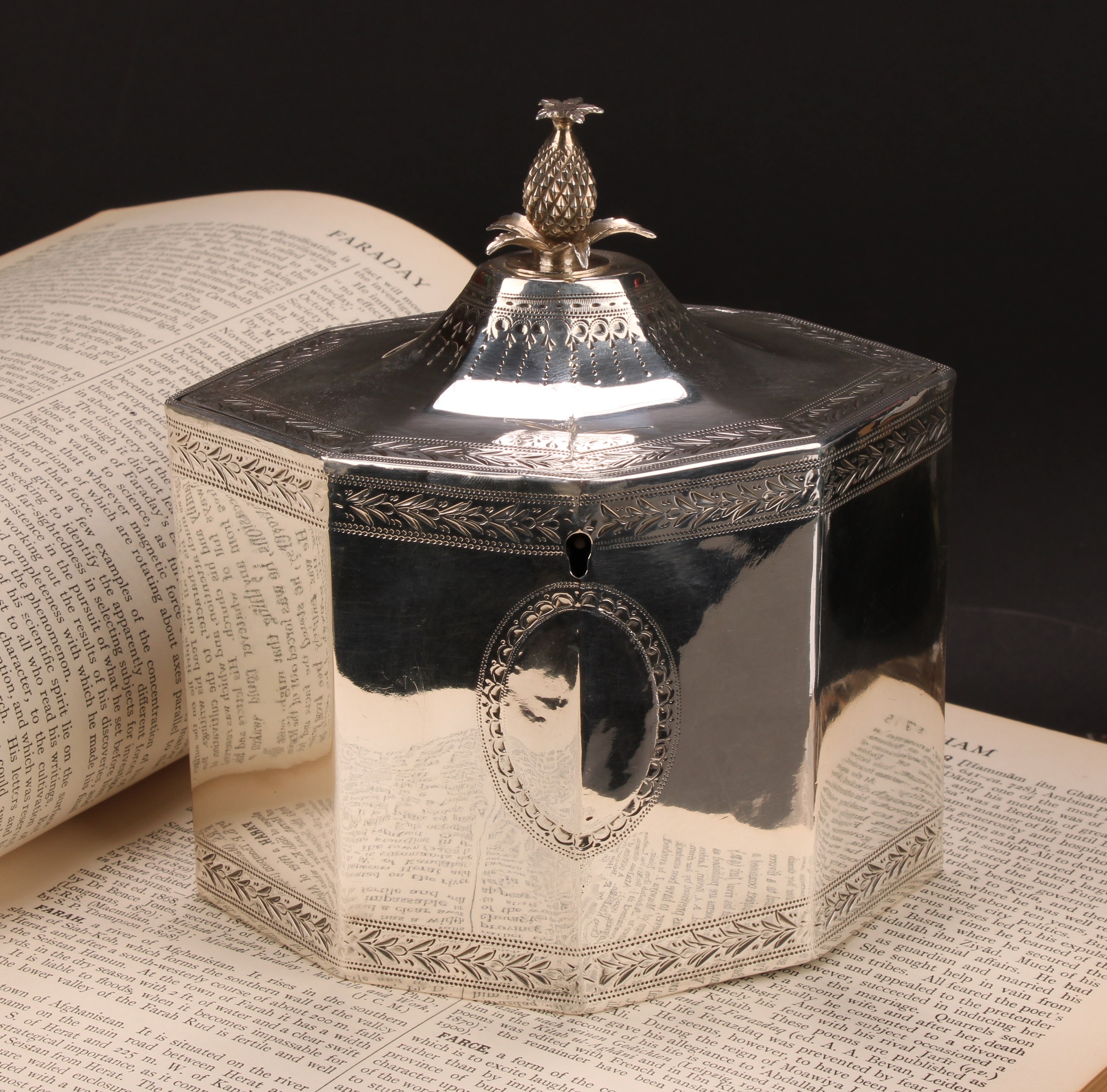 A George III silver octagonal tea caddy, flush-hinged cover with pine apple finial, bright-cut