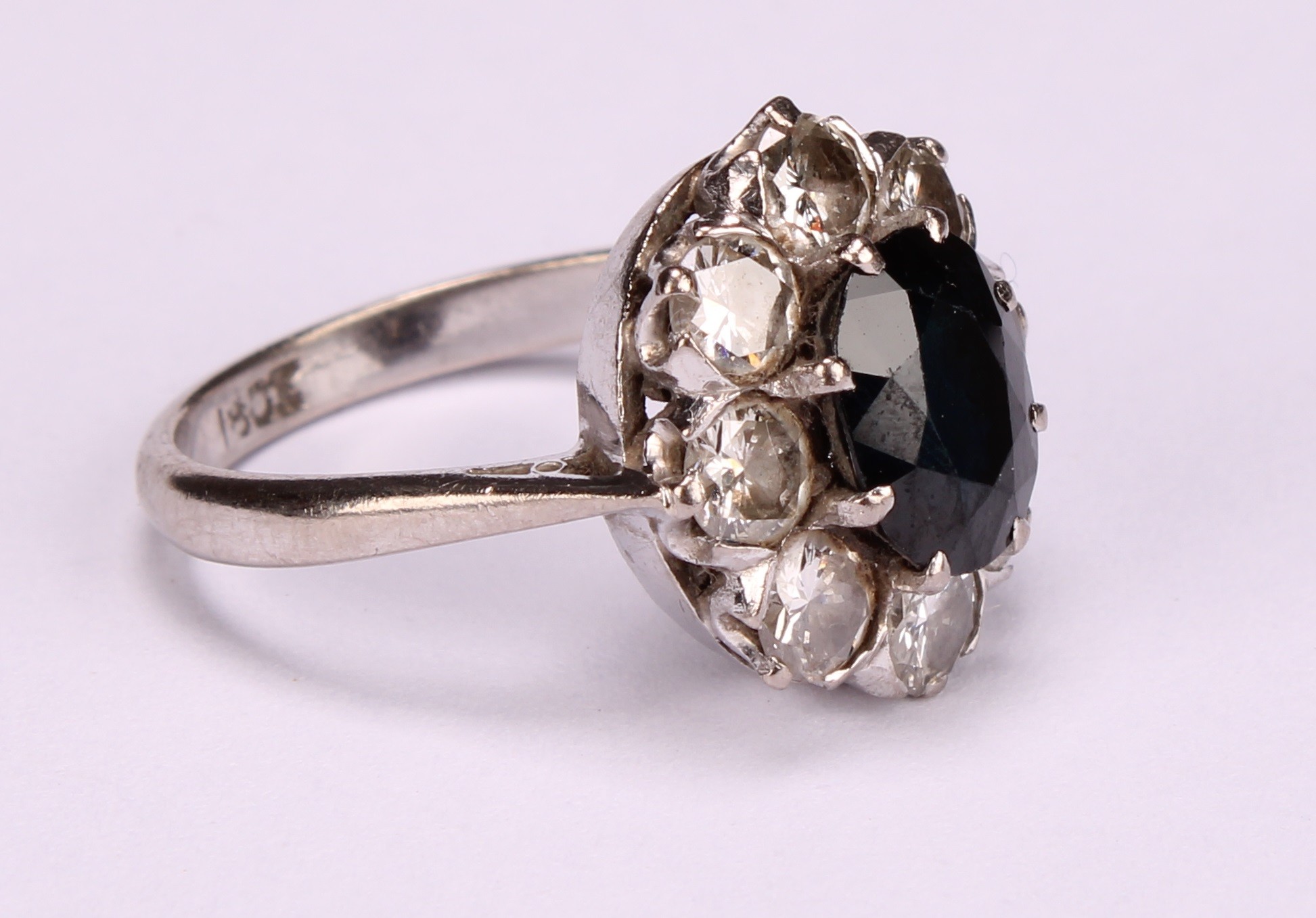 A sapphire, diamond and 18ct white gold cluster ring, the central oval facet cut stone claw set - Image 2 of 5