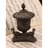 A Regency dark patinated bronze half-fluted campana inkwell, the incurve canted triform base applied