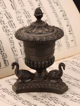 A Regency dark patinated bronze half-fluted campana inkwell, the incurve canted triform base applied