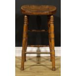 A Victorian public house tavern stool, saddle seat, ring-turned legs and stretchers, lacquered brass