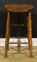 A Victorian public house tavern stool, saddle seat, ring-turned legs and stretchers, lacquered brass