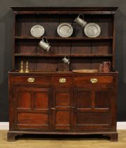 A George III oak and fruitwood dresser, outswept cornice above a plate rack, the projecting base