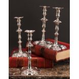 A composed set of four George II/early George III cast table candlesticks, detachable nozzles,