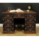 A late Victorian oak twin pedestal desk, rectangular top with foliate carved edge and inset