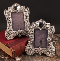 A pair of Victorian silver easel photograph frames, pierced and profusely embossed with flowers