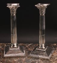 A pair of Edwardian silver stop-fluted Corinthian column table candlesticks, detachable nozzles,